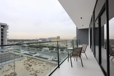 a balcony with a table and chairs and a view of a city at Livbnb-Stylish and Spacious 1BR Apartment with Private Balcony in Dubai