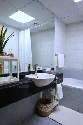 a bathroom with a sink and a tub and a mirror at Nice Place in Dubai