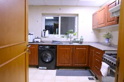 a kitchen with a washing machine and a sink at Nice Place in Dubai