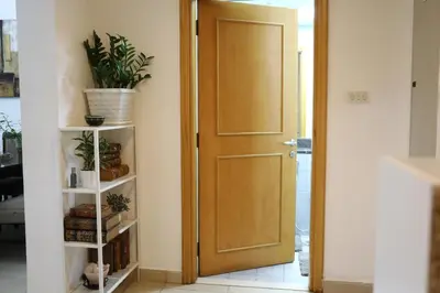 a wooden door in a room with a plant on a shelf at Nice Place in Dubai