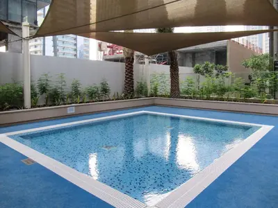 a swimming pool with an umbrella on top of a building at GuestReady - Marina Gate Studio Suite in Dubai