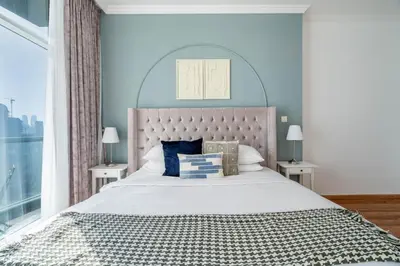 a bedroom with a large bed with a large window at GuestReady - Modern living in Downtown Dubai in Dubai