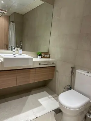 a bathroom with a sink and a toilet and a mirror at Azizi Riviera 44 in Dubai