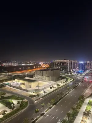 a city street at night with buildings and a road at Azizi Riviera 44 in Dubai