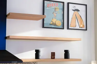 two shelves on a wall with two framed pictures at Urbane 1BR in Dubai Hills in Dubai