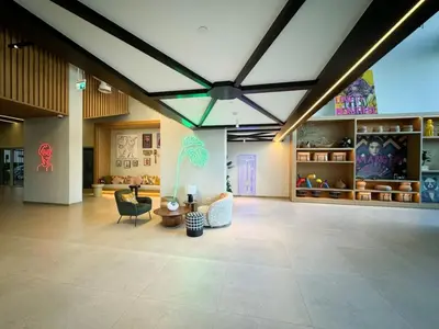 a living room with a ceiling fan and chairs at Urbane 1BR in Dubai Hills in Dubai