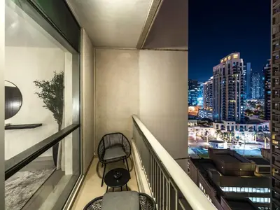 a balcony with a chair and a view of a city at Stylish 1BR - Burj Khalifa View in Dubai