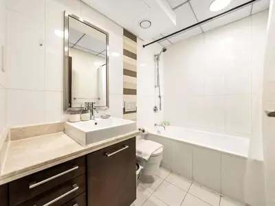 a bathroom with a sink and a toilet and a mirror at Stylish 1BR - Burj Khalifa View in Dubai