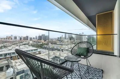 a balcony with two chairs and a view of the city at Lovely 1BR flat wBalcony Gym & Pool in JVC in Dubai