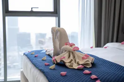 a bed with pink hearts on it with a pile of clothes at Rooftop Lounge - Walk to Dubai Mall & Burj Khalifa - Downtown in Dubai