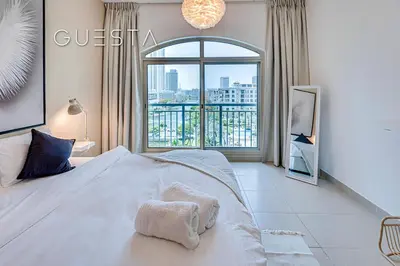 a bedroom with a bed and a large window at The Views & Greens - Mosela Tower, Dubai in Dubai