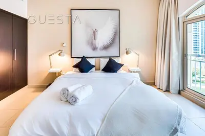 a bedroom with a white bed with two towels on it at The Views & Greens - Mosela Tower, Dubai in Dubai