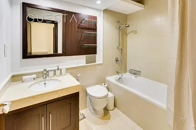 a bathroom with a sink and a toilet and a bath tub at The Views & Greens - Mosela Tower, Dubai in Dubai