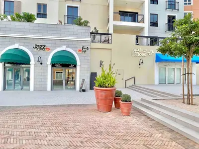 a building with some plants in front of it at 50 Shades of Grey Luxury Apartment near Beach in Dubai