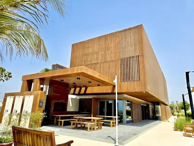 a house with a wooden facade with tables and benches at 50 Shades of Grey Luxury Apartment near Beach in Dubai