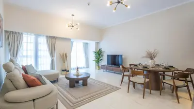 a living room with a couch and a dining room at Breathtaking Marina 2BR in Iconic Cayan Tower - 7AB08 in Dubai