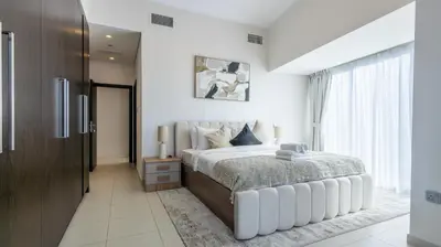 a white bedroom with a large bed and a window at Breathtaking Marina 2BR in Iconic Cayan Tower - 7AB08 in Dubai