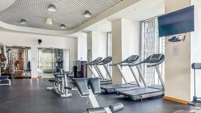 a gym with a row of treadmills at Breathtaking Marina 2BR in Iconic Cayan Tower - 7AB08 in Dubai