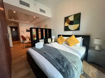 a bedroom with a large bed with yellow pillows at Higuest - Lake-view Studio in JLT in Dubai