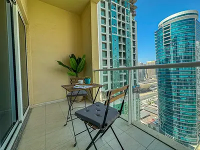 a chair on a balcony with a view of a city at Higuest - Lake-view Studio in JLT in Dubai