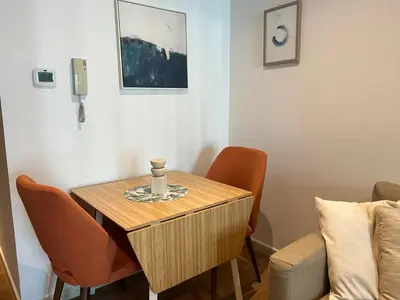 a small table in a room with orange chairs at Higuest - Lake-view Studio in JLT in Dubai