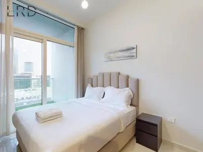 a bedroom with a large bed with a large window at Elegant 1BR with Stunning Canal Views in Dubai