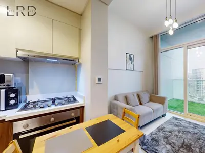 a kitchen with a stove and a couch in a room at Elegant 1BR with Stunning Canal Views in Dubai