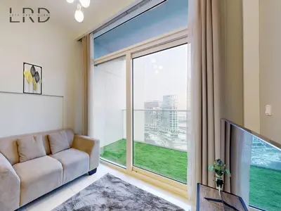 a living room with a couch and a large window at Elegant 1BR with Stunning Canal Views in Dubai