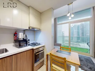 a kitchen with a table and a small kitchen with a window at Elegant 1BR with Stunning Canal Views in Dubai