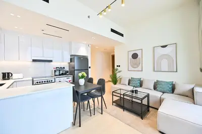 a kitchen and living room with a couch and a table at Stunning 1 Bdr luxury residence at JVC in Dubai