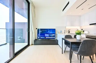 a kitchen and dining room with a table and chairs at Stunning 1 Bdr luxury residence at JVC in Dubai