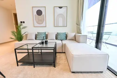 a living room with a white couch and a glass table at Stunning 1 Bdr luxury residence at JVC in Dubai