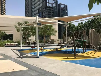 a playground with a slide and a play structure at Stylish 1BR with Pool, Gym, BBQ Area & Playground in Dubai