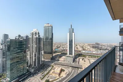 a view of a city from the balcony of a skyscraper at Stylish 1BR with Pool, Gym, BBQ Area & Playground in Dubai