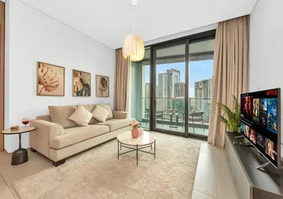 a living room with a couch and a tv at Address Residences Stay in Dubai