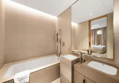 a bathroom with two sinks and a tub and a mirror at Address Residences Stay in Dubai