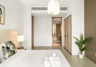 a bedroom with a large white bed and a hallway at Address Residences Stay in Dubai