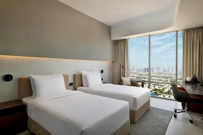 two beds in a hotel room with a view of the city at Hotel Local Dubai, Jumeirah Village Triangle, Autograph Collection in Dubai