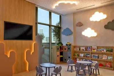 a classroom with tables and chairs and a flat screen tv at Hotel Local Dubai, Jumeirah Village Triangle, Autograph Collection in Dubai