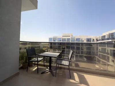 a table and chairs on the balcony of a building at Elite Business & Family Turnkey 433 Residence 2BR in OIA Motor City in Dubai