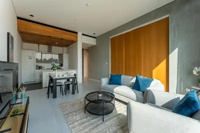 a living room with a couch and a table at HAVN - 1 Bed at KOA Canvas, Access to Nasab Dubai in Dubai
