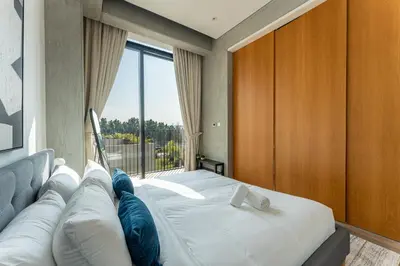 a bedroom with a bed and a large window at HAVN - 1 Bed at KOA Canvas, Access to Nasab Dubai in Dubai