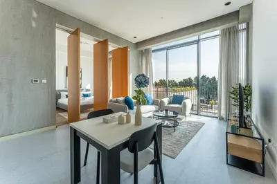 a living room with a table and chairs and a couch at HAVN - 1 Bed at KOA Canvas, Access to Nasab Dubai in Dubai