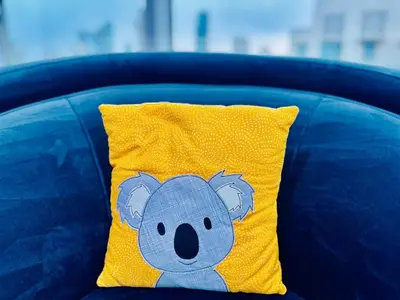 a yellow pillow with a teddy bear on it at Dubai I Burj Residence Retreat I Piano & Workstation in Dubai