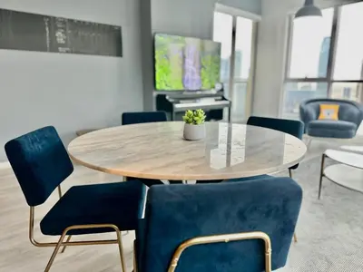 a dining room with a table and blue chairs at Dubai I Burj Residence Retreat I Piano & Workstation in Dubai