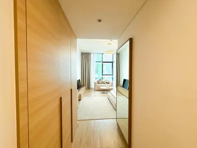 a hallway leading to a living room with a mirror at Modern Studio Living in JVC's Regina Tower in Dubai