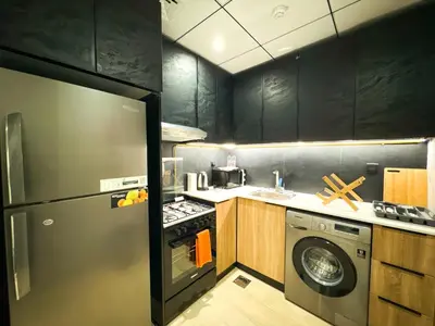a kitchen with a stainless steel refrigerator and a dishwasher at Modern Studio Living in JVC's Regina Tower in Dubai