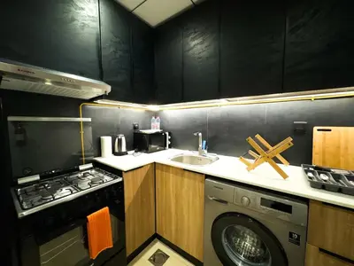a kitchen with a washing machine and a sink at Modern Studio Living in JVC's Regina Tower in Dubai