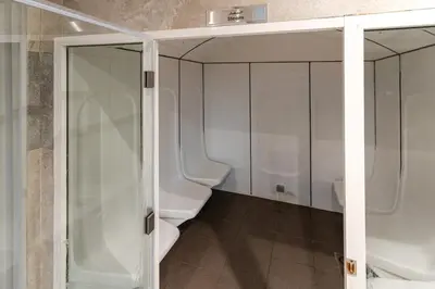 a bathroom with a glass shower and two toilets at Modern furnishing City Centre Super speed wifi in Dubai