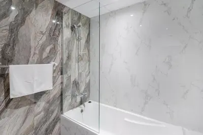 a bathroom with a shower and a tub and a sink at Modern furnishing City Centre Super speed wifi in Dubai
